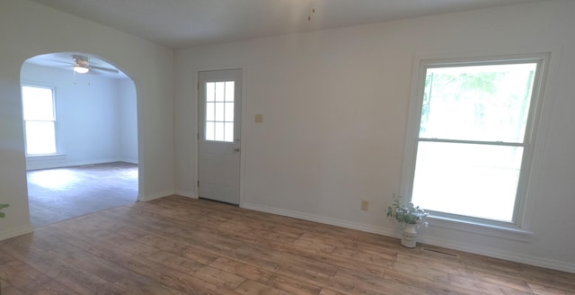 221 Boisseau St, Greenfield, MO 65661 - unfurnished room with arched walkways, a ceiling fan, wood finished floors, and baseboards