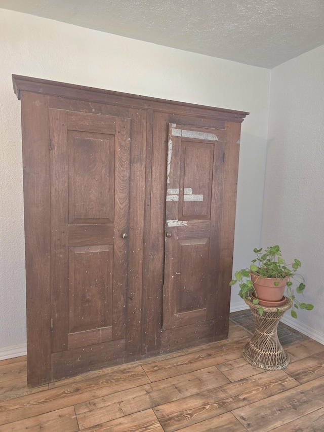 221 Boisseau St, Greenfield, MO 65661 - detailed view of wood finished floors, baseboards, and a textured ceiling