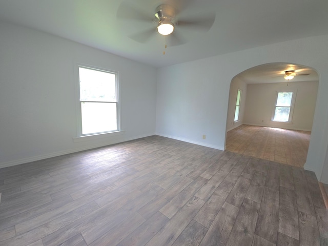 221 Boisseau St, Greenfield, MO 65661 - spare room featuring ceiling fan, arched walkways, and wood finished floors