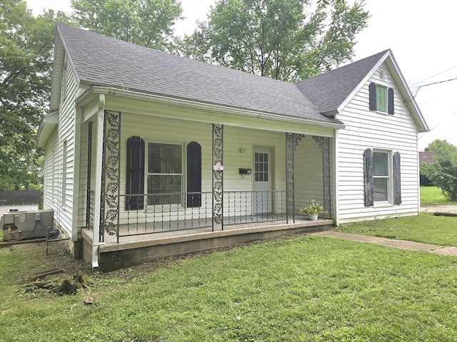 221 Boisseau St, Greenfield, MO 65661 - view of front of house with a porch, central AC, roof with shingles, and a front lawn