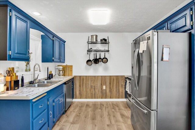 113 Holly Ridge Rd, Willard, MO 65781 - kitchen with appliances with stainless steel finishes, blue cabinets, a sink, light countertops, and wainscoting
