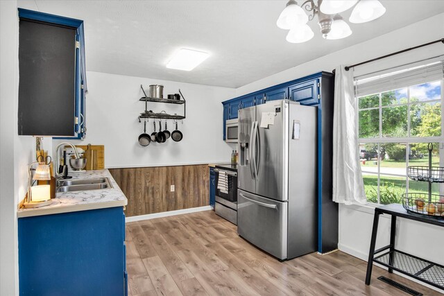 113 Holly Ridge Rd, Willard, MO 65781 - kitchen with appliances with stainless steel finishes, blue cabinets, a sink, light countertops, and light wood finished floors