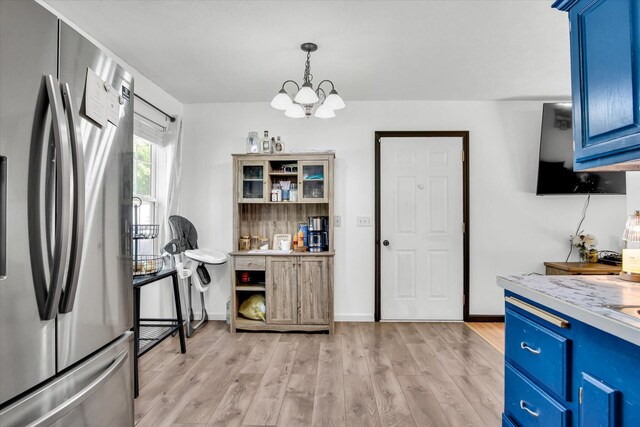 113 Holly Ridge Rd, Willard, MO 65781 - kitchen with freestanding refrigerator, blue cabinets, a chandelier, light wood finished floors, and light countertops
