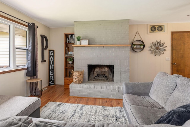225 Elim St, Forsyth, MO 65653 - living area with wood finished floors, a brick fireplace, and baseboards