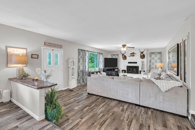 21371 Howell Rd, Mountain View, MO 65548 - living room with ceiling fan, wood finished floors, a fireplace, and baseboards