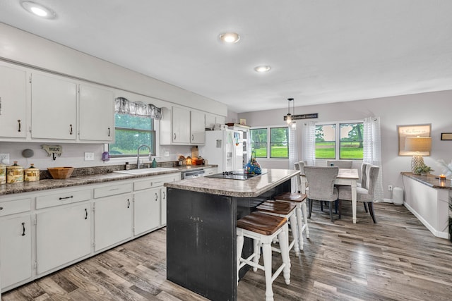 21371 Howell Rd, Mountain View, MO 65548 - kitchen with a sink, white fridge with ice dispenser, a kitchen breakfast bar, light wood-type flooring, and healthy amount of natural light