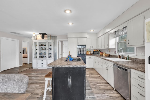 21371 Howell Rd, Mountain View, MO 65548 - kitchen with black appliances, a sink, a center island, white cabinetry, and a kitchen bar