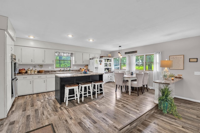 21371 Howell Rd, Mountain View, MO 65548 - kitchen with a sink, wood finished floors, white fridge with ice dispenser, white cabinets, and recessed lighting