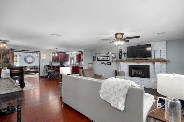 2526 State Highway B, Rogersville, MO 65742 - living area featuring ceiling fan, dark wood finished floors, a brick fireplace, and a barn door