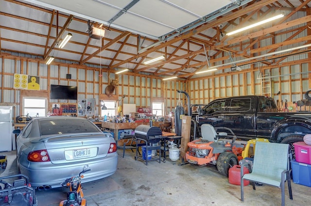 2526 State Highway B, Rogersville, MO 65742 - garage featuring metal wall, a workshop area, a garage door opener, and freestanding refrigerator