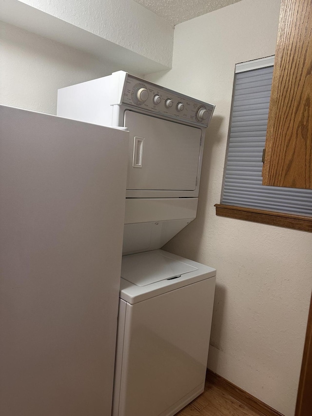 154A Scofield Ave, Forsyth, MO 65653 - washroom with stacked washing machine and dryer and wood finished floors