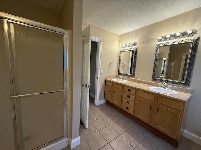 895 W Linwood Ave, Nixa, MO 65714 - bathroom with double vanity, tile patterned floors, a stall shower, baseboards, and a textured ceiling