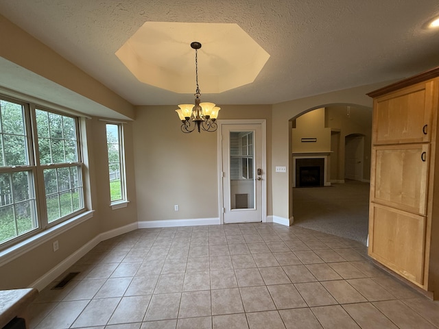 895 W Linwood Ave, Nixa, MO 65714 - unfurnished dining area featuring a chandelier, light tile patterned flooring, arched walkways, baseboards, and a textured ceiling