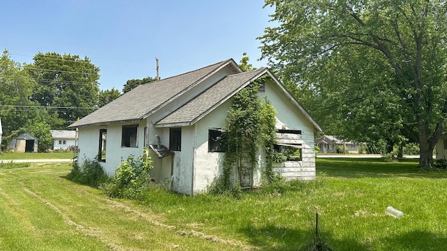 401 W Clouse St, Mountain Grove, MO 65711 - view of side of property featuring stucco siding, a lawn, and a shingled roof