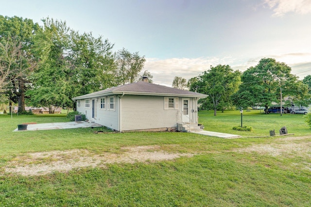 510 E College St, Walnut Grove, MO 65770 - rear view of property with entry steps, a yard, a patio area, a chimney, and view of wooded area