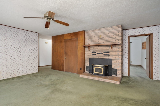 510 E College St, Walnut Grove, MO 65770 - unfurnished living room featuring carpet flooring, a wood stove, a ceiling fan, a textured ceiling, and wallpapered walls
