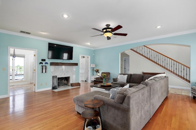 4402 Quail Run Rd, Ozark, MO 65721 - living area featuring arched walkways, ceiling fan, ornamental molding, stairs, and light wood finished floors