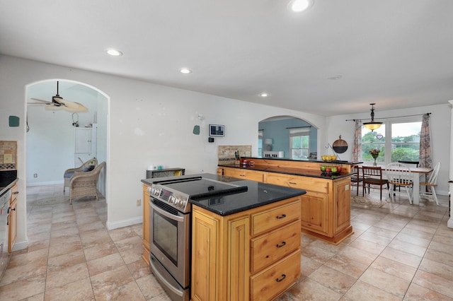 4402 Quail Run Rd, Ozark, MO 65721 - kitchen with a kitchen island, stainless steel electric stove, arched walkways, dark countertops, and recessed lighting