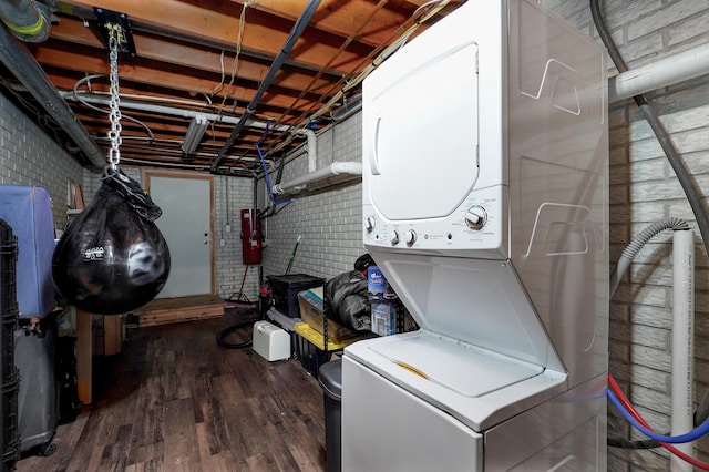 4402 Quail Run Rd, Ozark, MO 65721 - washroom with stacked washing machine and dryer, wood finished floors, and brick wall