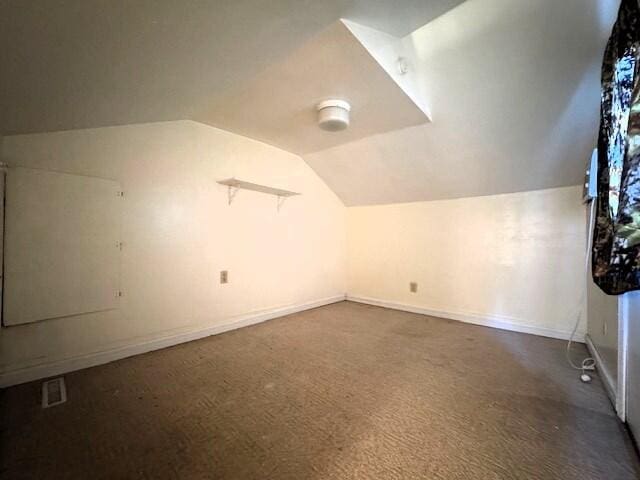 1211 W Calhoun St, Springfield, MO 65802 - additional living space with lofted ceiling, dark colored carpet, and baseboards