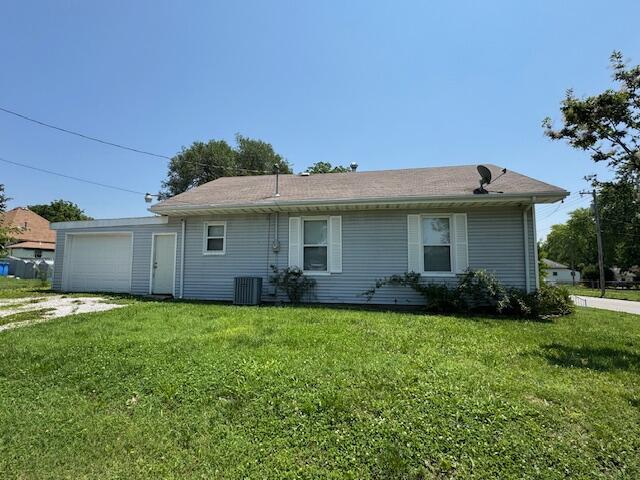 1211 W Calhoun St, Springfield, MO 65802 - rear view of property featuring a lawn, cooling unit, and driveway