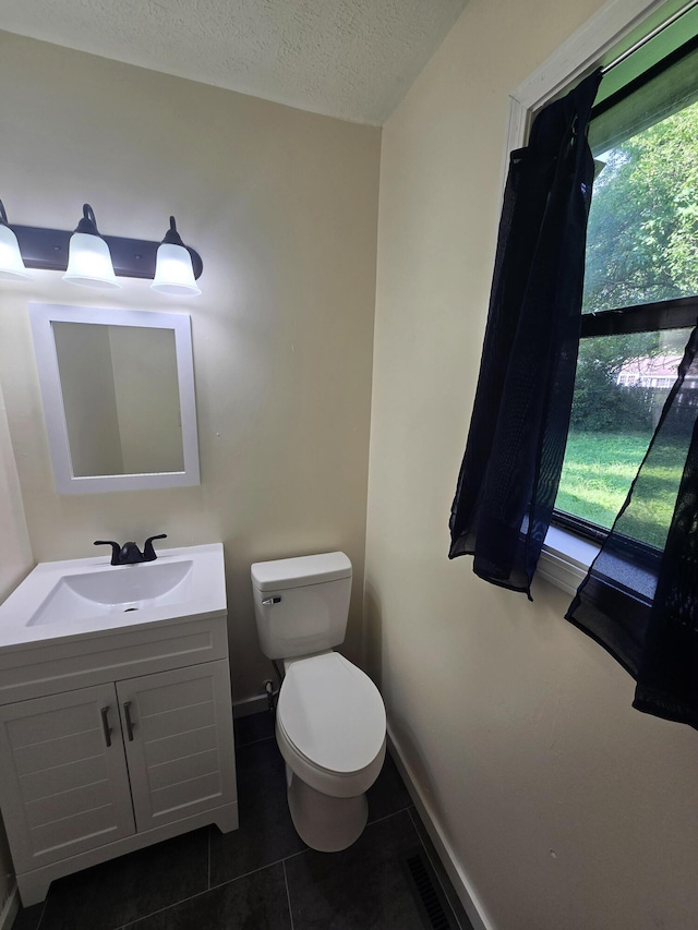 2460 S National Ave, Springfield, MO 65804 - half bath with toilet, vanity, tile patterned floors, baseboards, and a textured ceiling