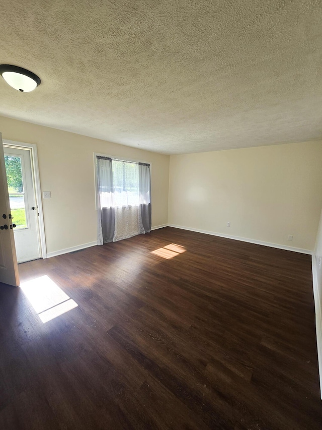 2460 S National Ave, Springfield, MO 65804 - unfurnished room with plenty of natural light, a textured ceiling, dark wood finished floors, and baseboards