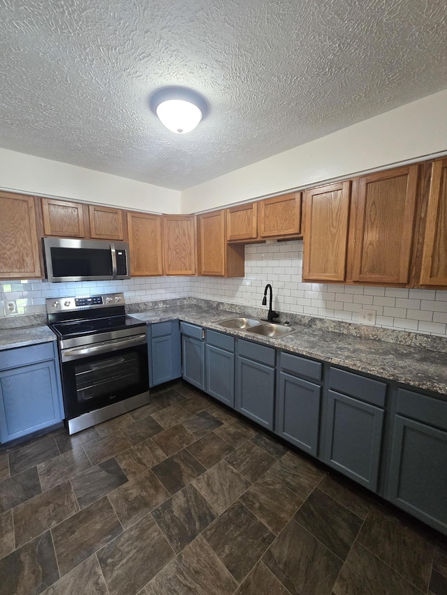 2460 S National Ave, Springfield, MO 65804 - kitchen with stainless steel appliances, a sink, tasteful backsplash, a textured ceiling, and dark countertops