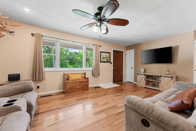 19326 Boat Dock Rd W, Omaha, AR 72662 - living room with a textured ceiling, light wood-style flooring, baseboards, and ceiling fan
