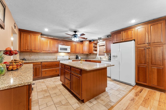 19326 Boat Dock Rd W, Omaha, AR 72662 - kitchen with white appliances, brown cabinets, light stone countertops, recessed lighting, and a textured ceiling