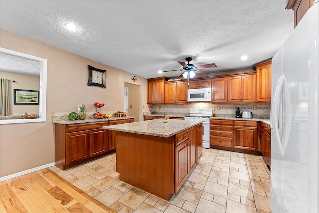 19326 Boat Dock Rd W, Omaha, AR 72662 - kitchen with white appliances, brown cabinetry, a textured ceiling, a kitchen island, and backsplash