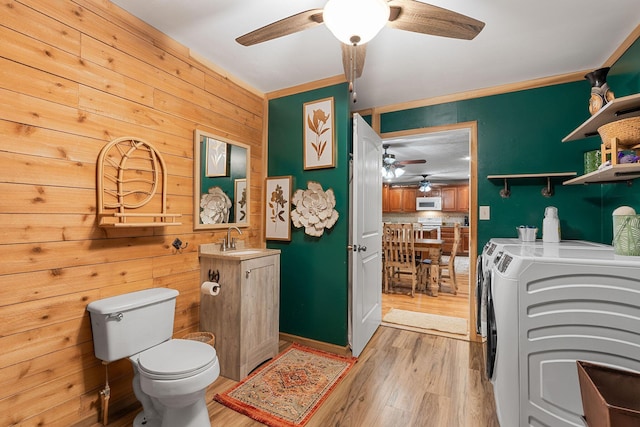 19326 Boat Dock Rd W, Omaha, AR 72662 - laundry area with ceiling fan, washer and dryer, light wood-style floors, and wood walls