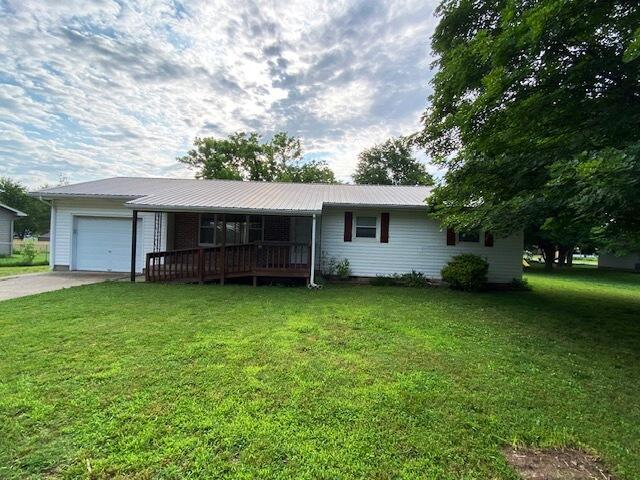 1208 Oak Ridge Dr, Aurora, MO 65605 - single story home featuring a garage, driveway, a front lawn, and metal roof