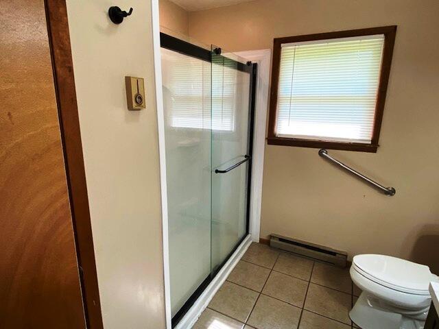 1208 Oak Ridge Dr, Aurora, MO 65605 - bathroom featuring baseboard heating, a shower stall, tile patterned floors, and toilet