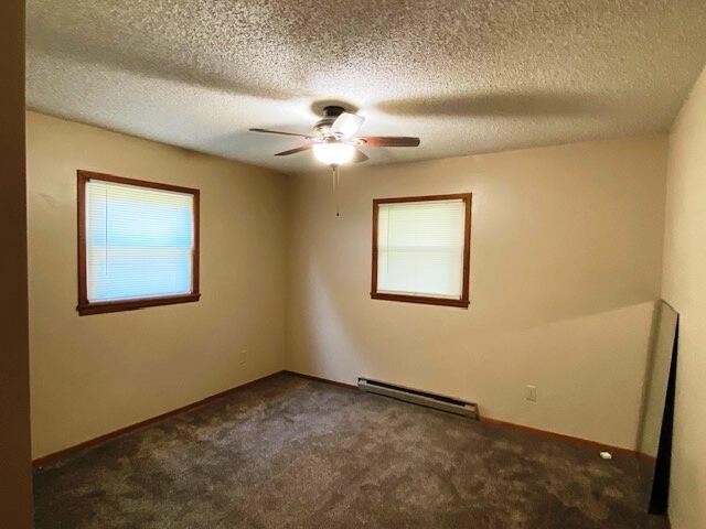 1208 Oak Ridge Dr, Aurora, MO 65605 - spare room with baseboard heating, carpet floors, a ceiling fan, and a textured ceiling