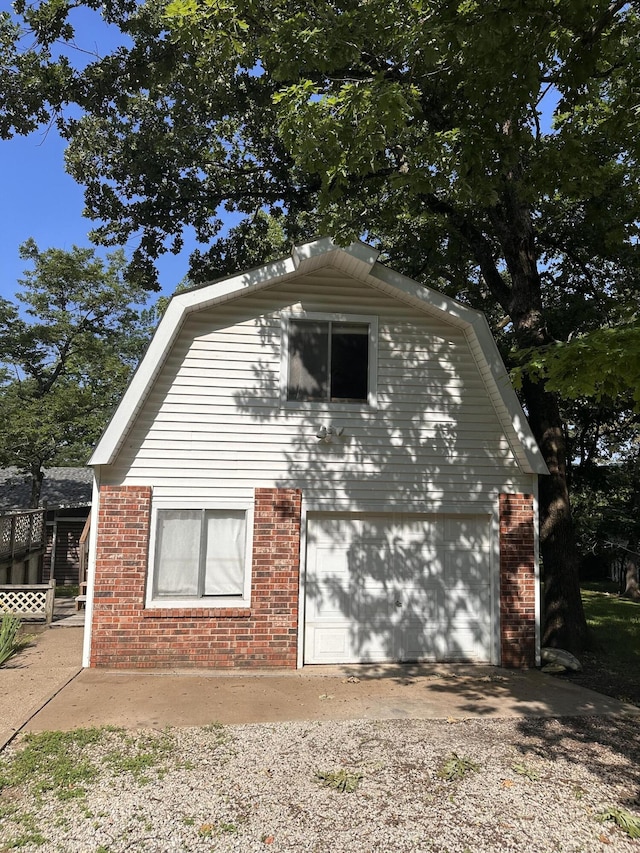 130 Wichita Ave, Forsyth, MO 65653 - view of side of home featuring brick siding, driveway, and an attached garage