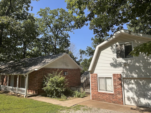 130 Wichita Ave, Forsyth, MO 65653 - view of side of home featuring brick siding, a garage, and a porch