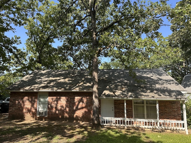 130 Wichita Ave, Forsyth, MO 65653 - view of front of house featuring brick siding, covered porch, roof with shingles, and cooling unit