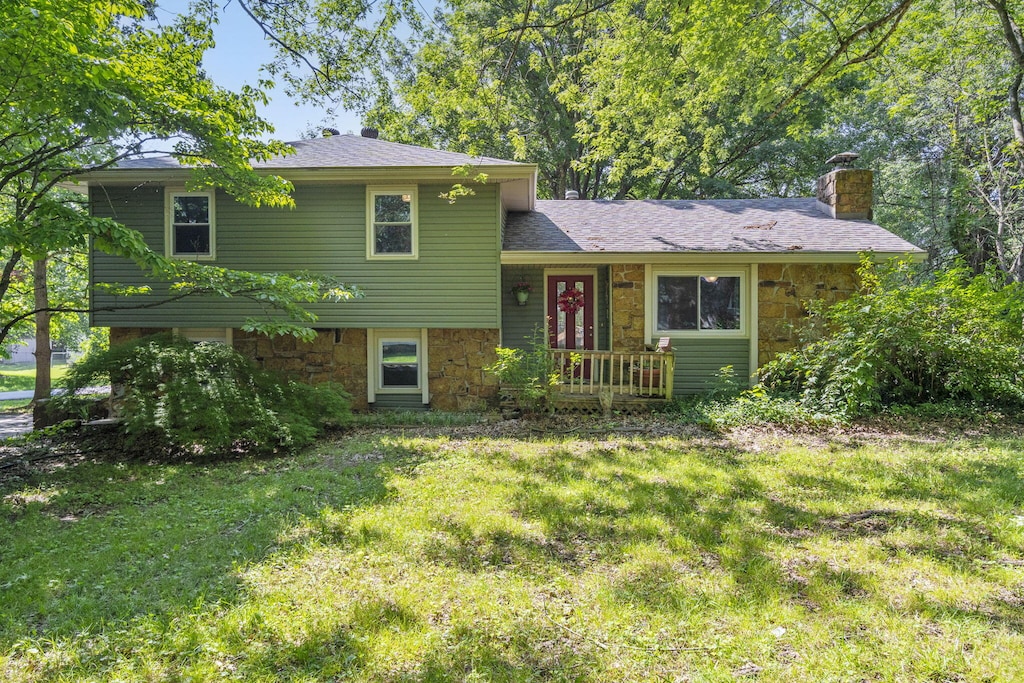 5527 S Honeysuckle Ln, Battlefield, MO 65619 - tri-level home featuring stone siding, a chimney, and a front lawn