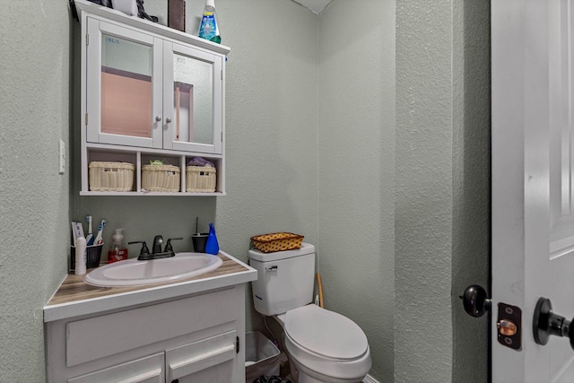 206 Plum St, Sparta, MO 65753 - bathroom with vanity, toilet, and a textured wall