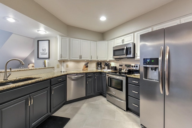 280 Wimbledon Dr Unit 9, Branson, MO 65616 - kitchen with stainless steel appliances, a sink, white cabinets, light tile patterned flooring, and light stone counters