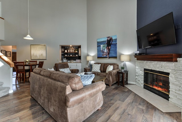 280 Wimbledon Dr Unit 9, Branson, MO 65616 - living area featuring a towering ceiling, a stone fireplace, wood finished floors, stairs, and a dry bar