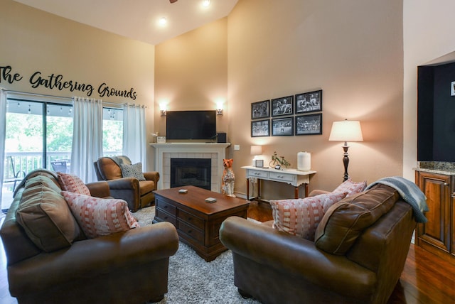 318 Wimbledon Dr Unit 8, Branson, MO 65616 - living room with a tiled fireplace, a high ceiling, dark wood-type flooring, and ceiling fan
