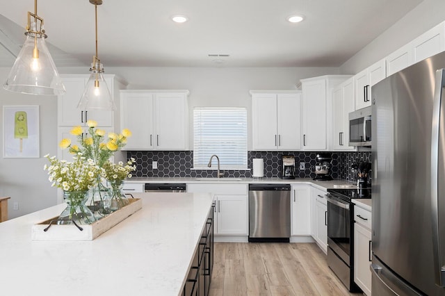 224 David Shawn Dr, Branson, MO 65616 - kitchen with appliances with stainless steel finishes, a sink, light wood-style floors, white cabinets, and recessed lighting