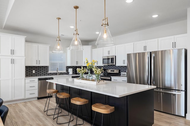 224 David Shawn Dr, Branson, MO 65616 - kitchen featuring stainless steel appliances, a kitchen island, decorative backsplash, light wood finished floors, and recessed lighting