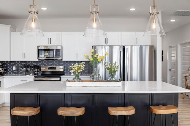 224 David Shawn Dr, Branson, MO 65616 - kitchen featuring appliances with stainless steel finishes, light wood finished floors, light countertops, a kitchen breakfast bar, and recessed lighting