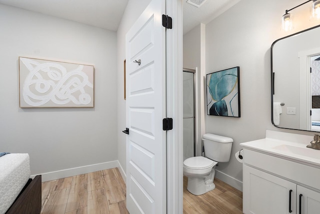 224 David Shawn Dr, Branson, MO 65616 - bathroom featuring vanity, wood finished floors, baseboards, toilet, and a shower with door