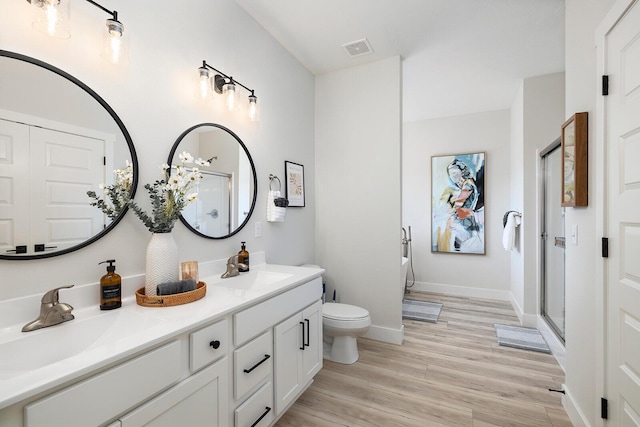 224 David Shawn Dr, Branson, MO 65616 - bathroom featuring toilet, double vanity, a stall shower, and wood finished floors