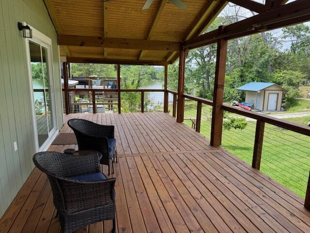 83 Dawn Cir, Galena, MO 65656 - deck featuring a ceiling fan, a storage shed, a water view, and a yard