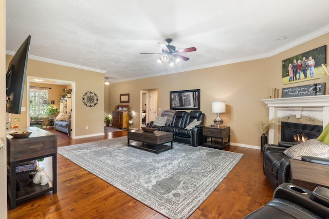 1002 S Joshua Ave, Republic, MO 65738 - living room with a ceiling fan, a warm lit fireplace, dark wood-style floors, ornamental molding, and baseboards